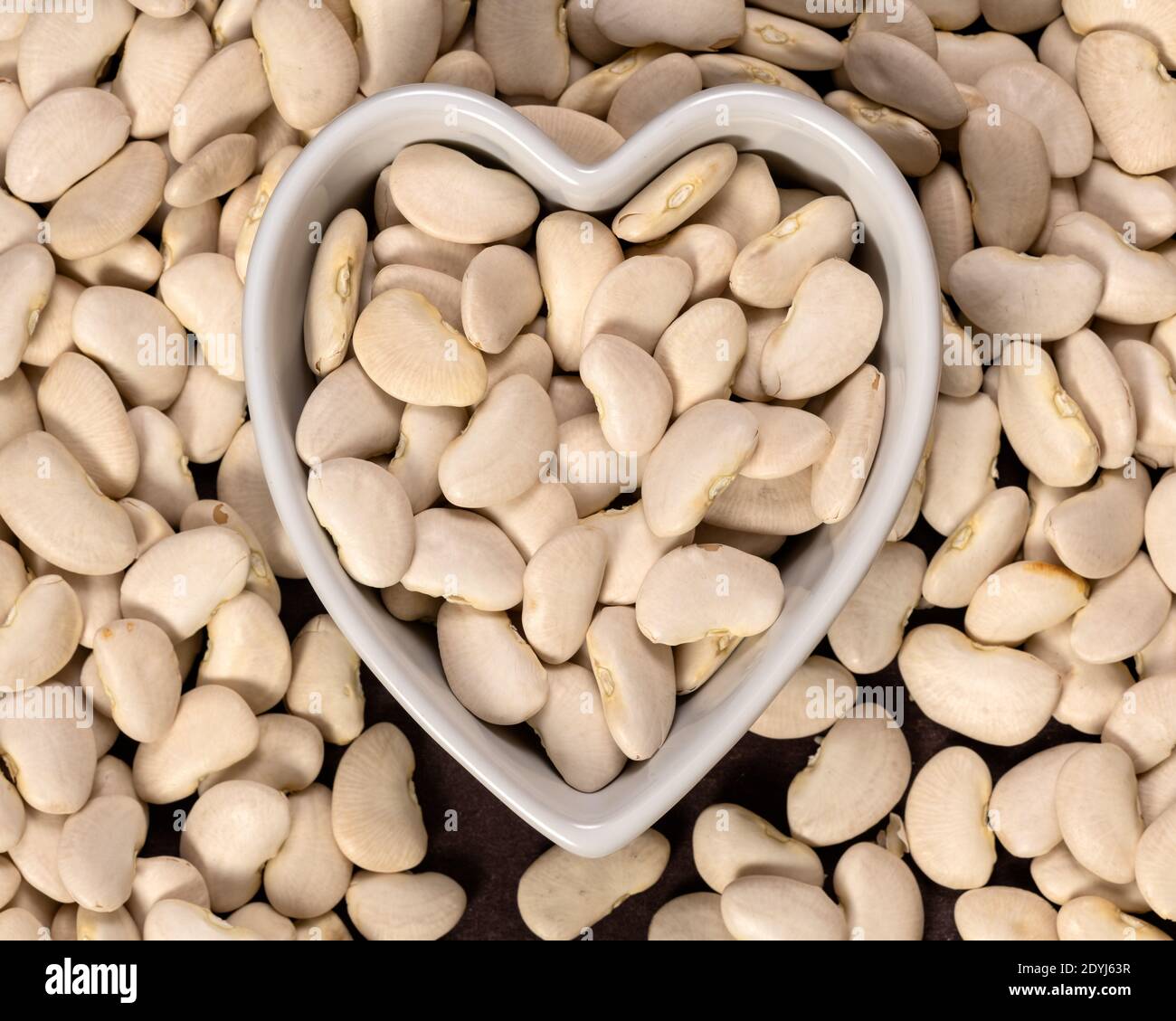 Large lima beans in a heart shaped bowl background and texture. Top
