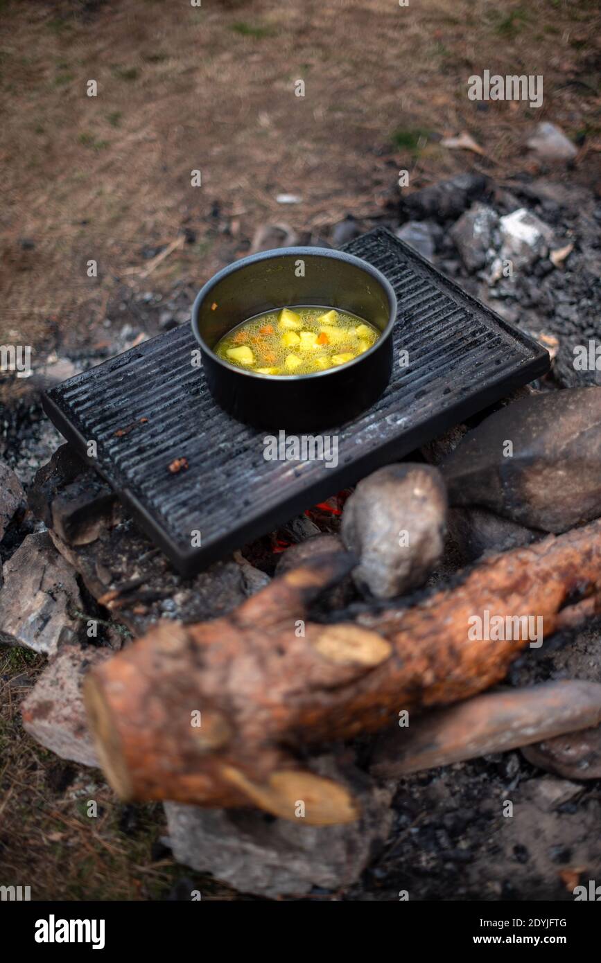 Cooking soup in cast iron boiler on burning campfire. Pot with soup over  the open fire outdoors. Tourism in Latvia. Cooking soup in a pot on  campfire Stock Photo - Alamy