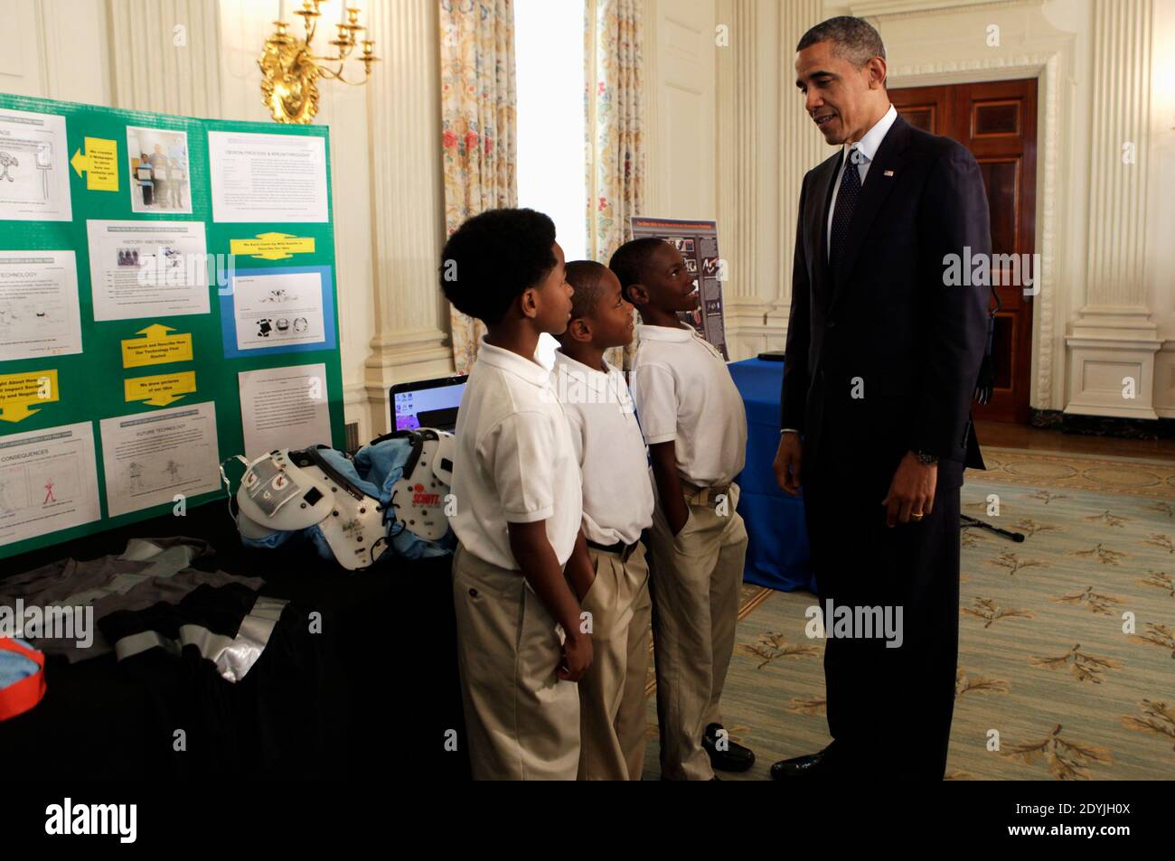 President Barack Obama looks at the COOL PADS for shoulders, helmet, armpits and groin created by Evan Jackson, Alec Jackson and Caleb Robinson, from Flippen Elementary School students from McDonough, Georgia, in the State Dining Room of the WHite House during the White House Science Fair in Washington, DC, USA, on April 22, 2013. The White House Science Fair celebrates the student winners of a broad range of science, technology, engineering and math (STEM) competitions from across the country. The first White House Science Fair was held in late 2010. Photo by Aude Guerrucci/Pool/ABACAPRESS.CO Stock Photo