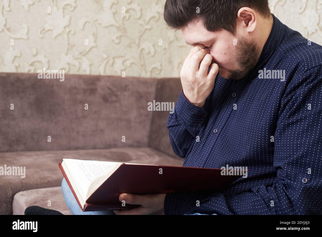 Concept, Caucasian man's eyes hurt while reading a book, copies of