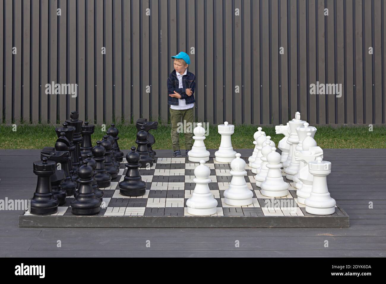 Saint-Petersburg, Russia, July 9, 2017. A young boy thinking about the move in chess, big street outdoor chess board, consept of making choice Stock Photo