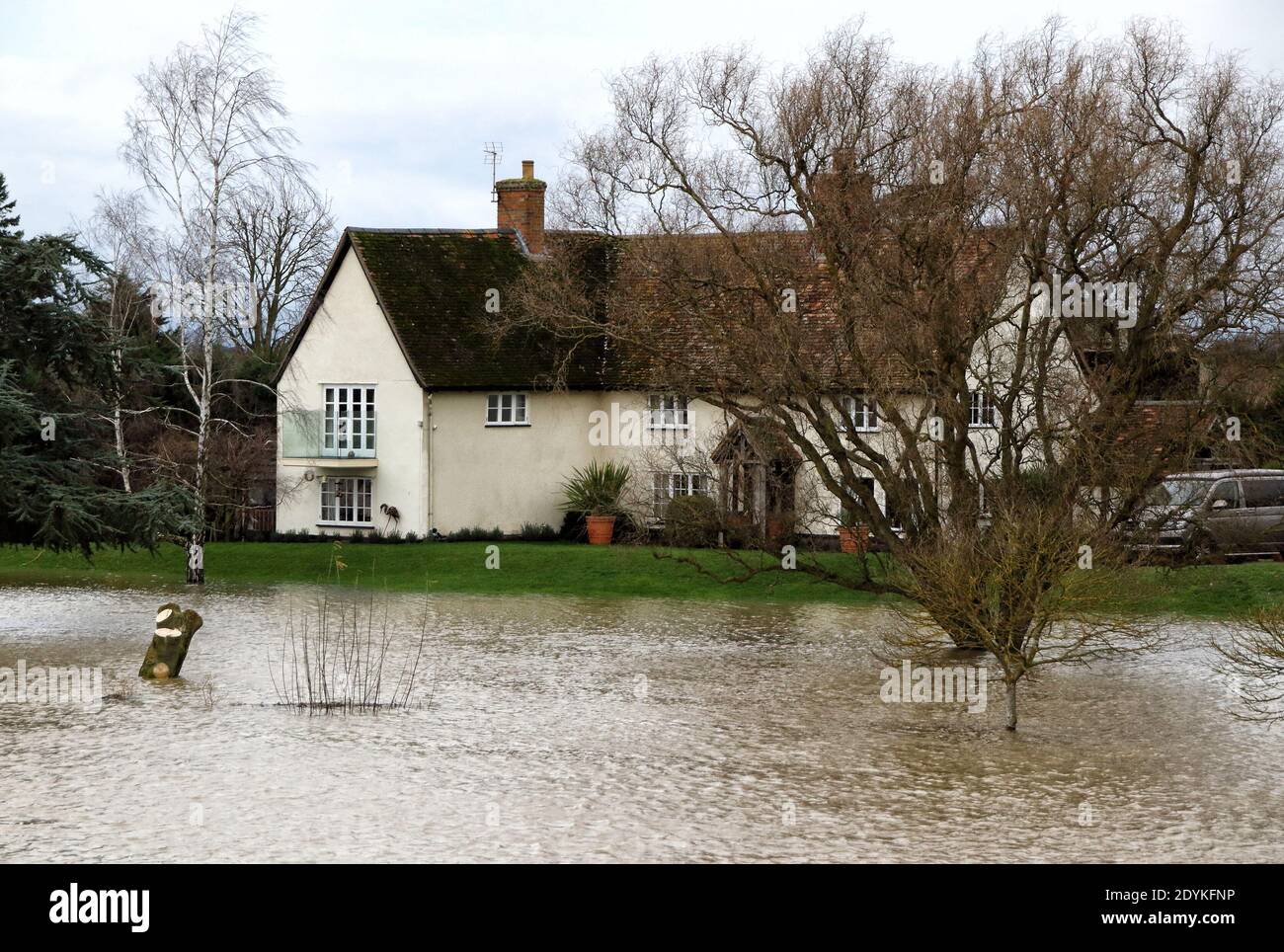 A house by the river is surrounded by water.Widespread flooding in Bedford and surrounding villages, where the River Great Ouse has burst its banks. Severe flood warnings were issued for areas along the River Great Ouse by the UK Environment Agency and residents living near the river were 'strongly urged' to seek alternative accommodation due to fears of floods. Stock Photo