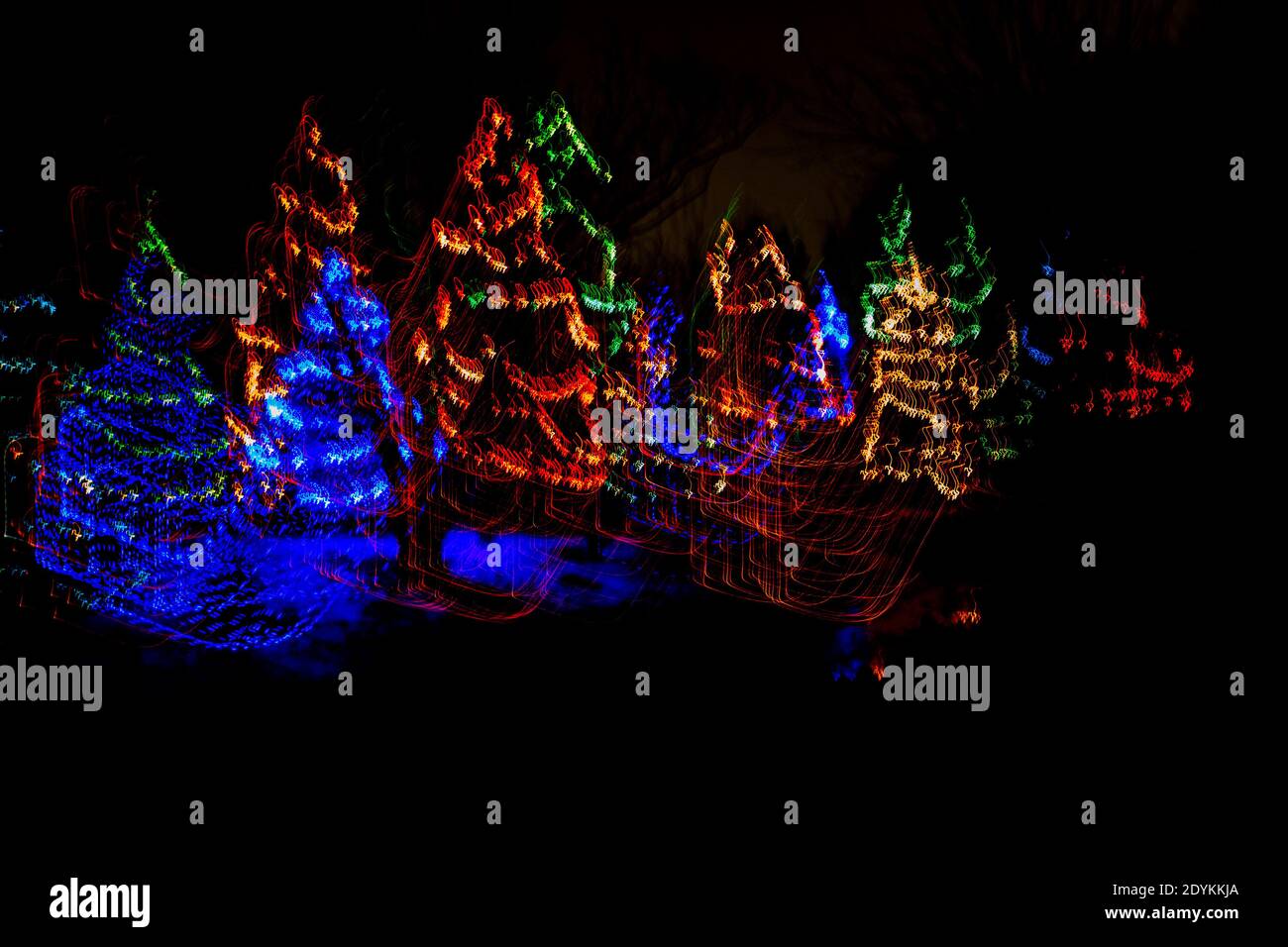 Glowing light line of Christmas trees. Abstract luminous light speed motion effect, horizontal Stock Photo