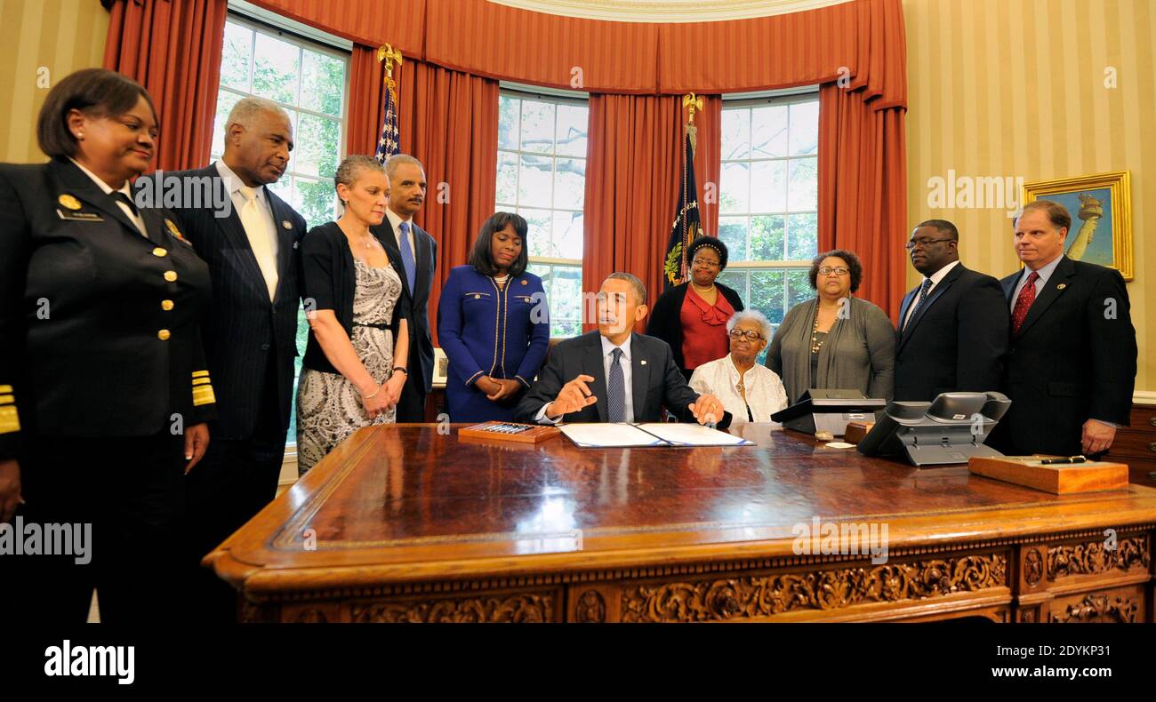 US President Barack Obama makes remarks before he signs a bill in the Oval Office, May 24, 2013 in Washington, DC, USA, designating the Congressional Gold Medal commemorating the lives of the four young girls killed in the 16th Street Baptist Church Bombings of 1963 in Birmingham, Alabama. Witnessing (L-R) Surgeon General Regina Benjamin, Birmingham Mayor William Bell, Dr Sharon Malone Holder, Attorney General Eric Holder, Rep Terri Sewell (D-AL), Thelma Pippen McNair (mother of Denise McNair), Lisa McNair (sister of Denise McNair), Dianne Braddock (sister of Carole Robertson), Rev Arthur Pric Stock Photo