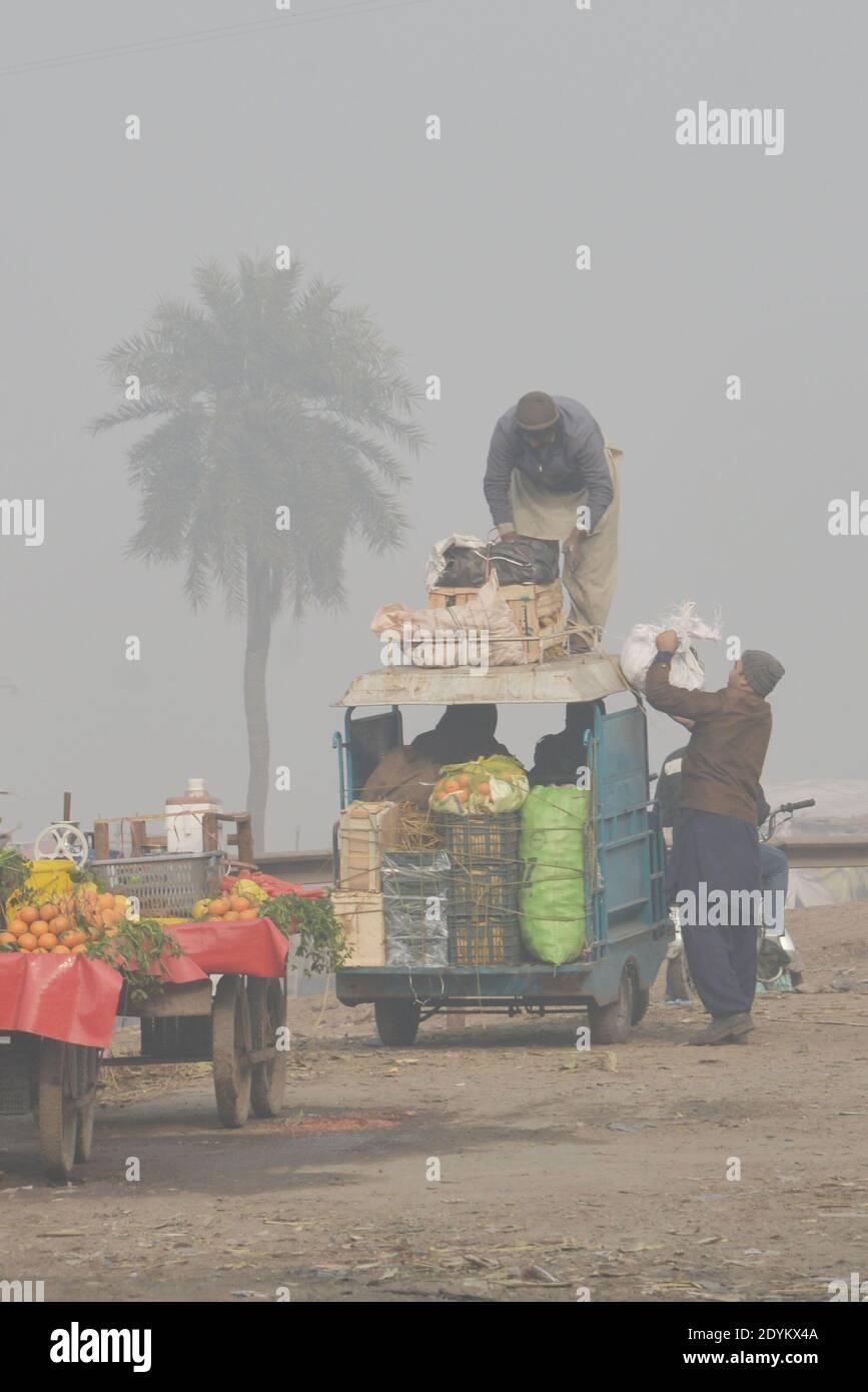 Lahore, Pakistan. 26th Dec, 2020. Commuters make their way amid dense