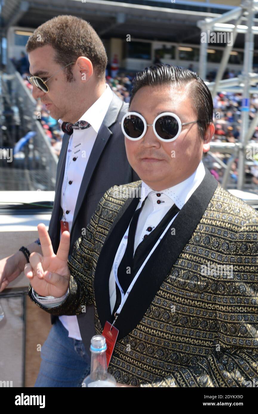 A Psy impersonator with fake bodyguard poses with visitors in the paddock  prior to the Formula One Grand Prix of Monaco, in Monaco, on May 26, 2013.  The man from rural France