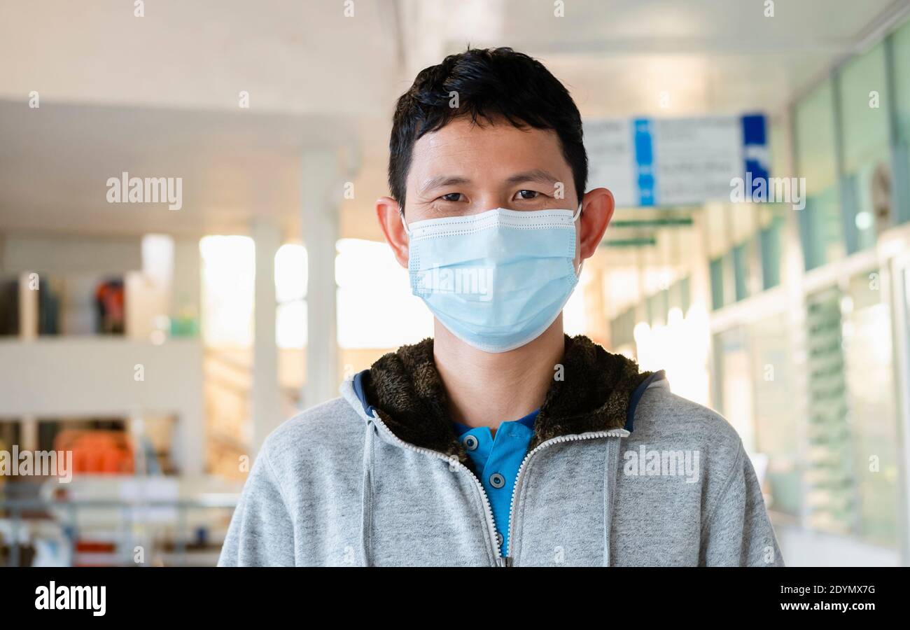 Man wearing a medicine mask in business public area protect himself from risk of disease, people prevent infection from coronavirus Covid-19 or Air Stock Photo
