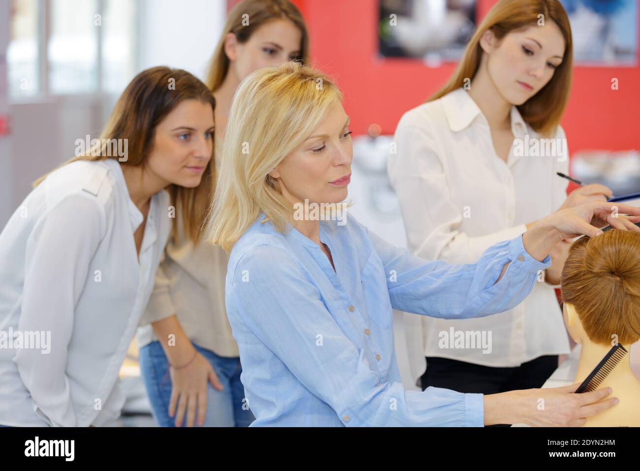 teacher helping students training to hairdressers Stock Photo