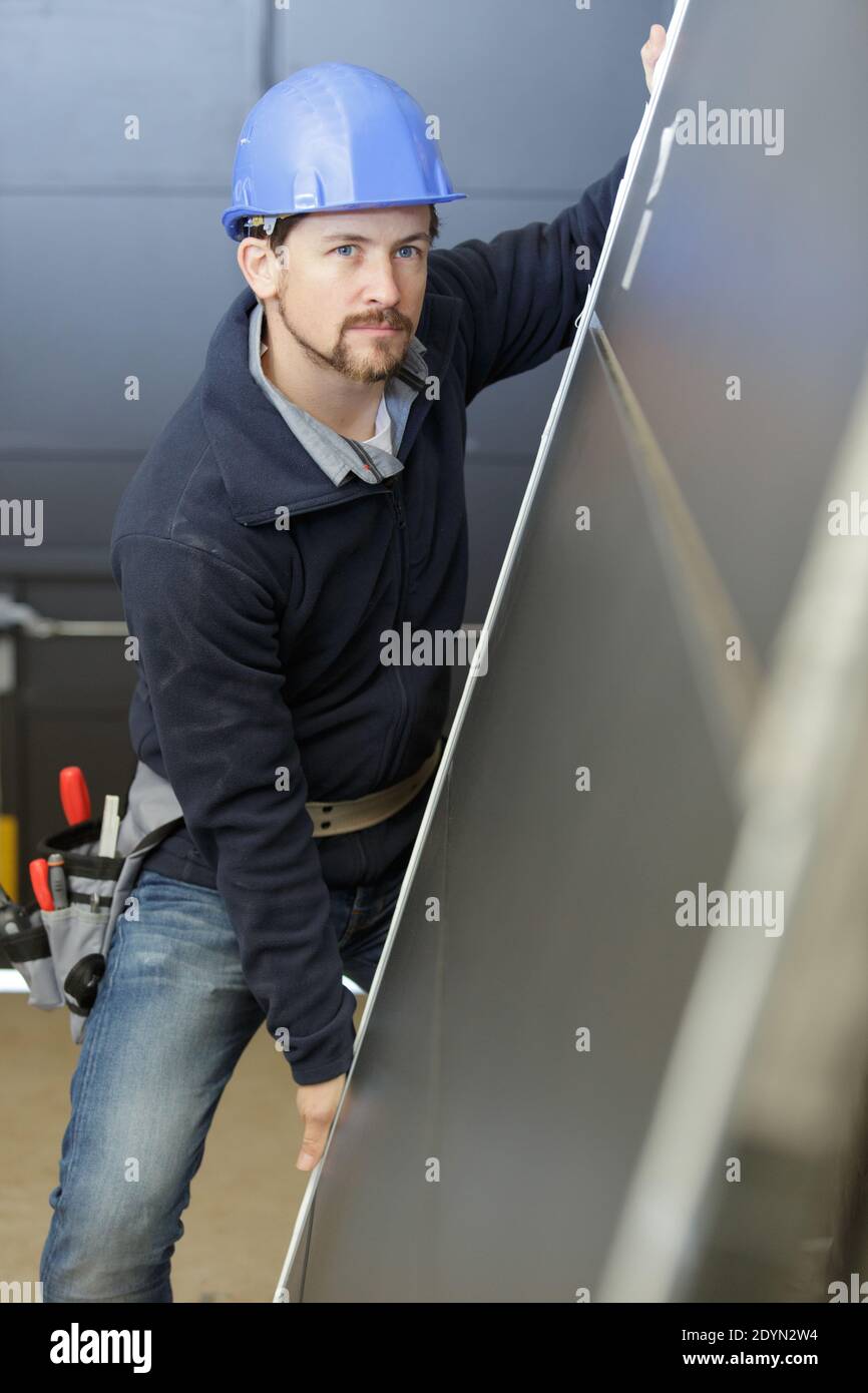 a man builder is holding a door Stock Photo
