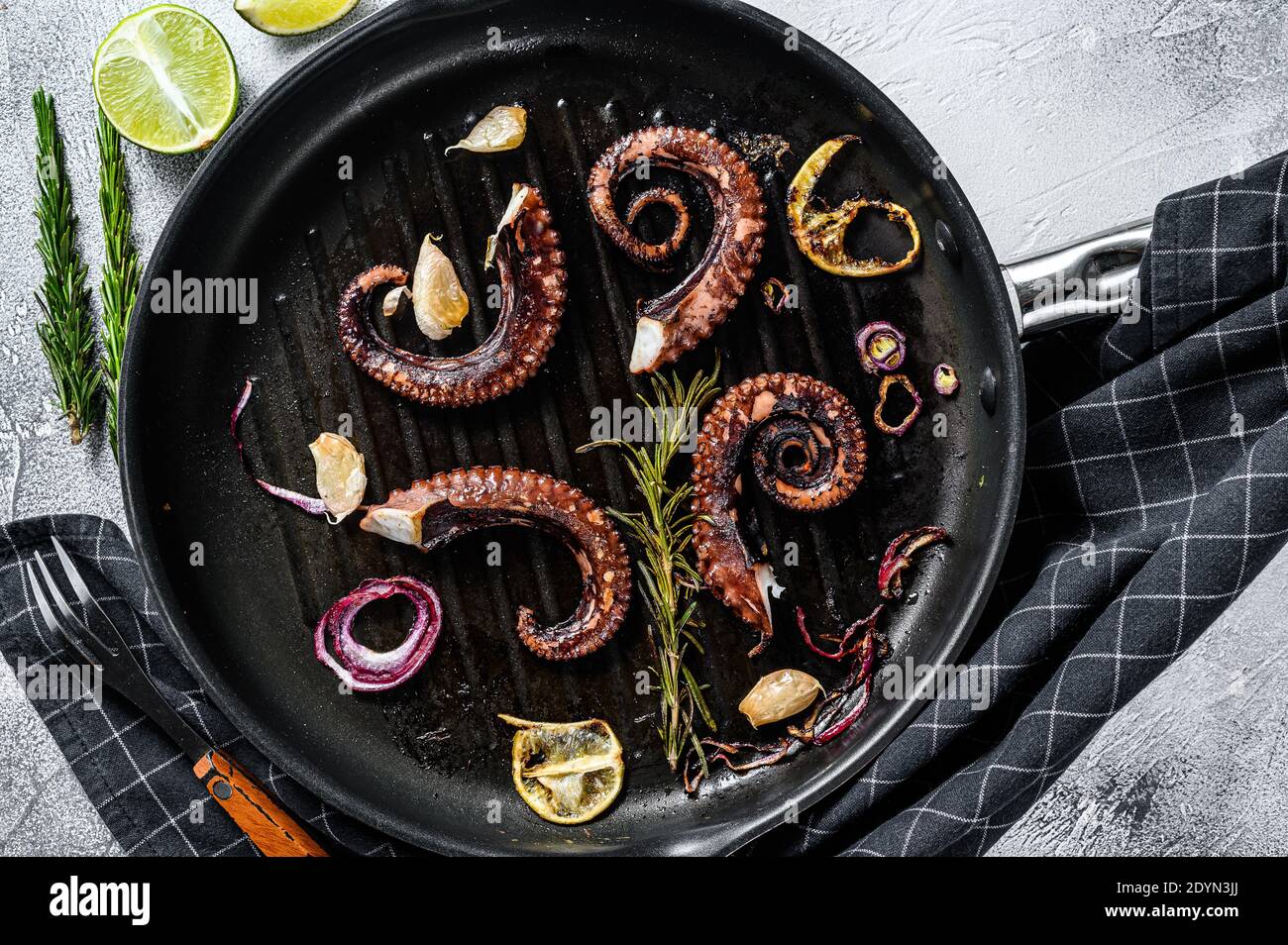 Fried octopus tentacles with rosemary, garlic and butter in a pan