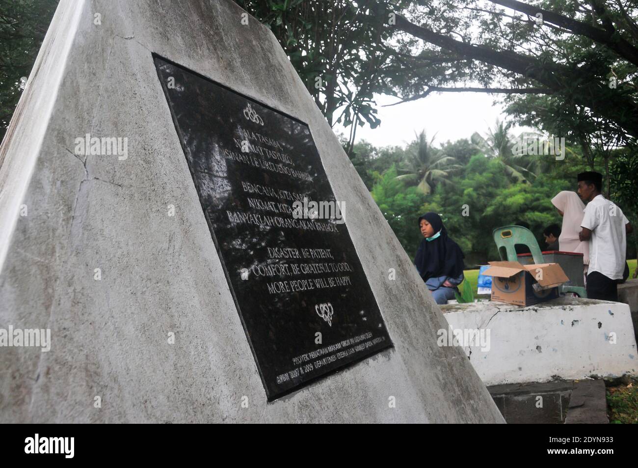 People pray at the mass burial complex for victims of the December 26, 2004 tsunami in the village of Siron, Aceh Besar, Aceh province, Indonesia. Stock Photo