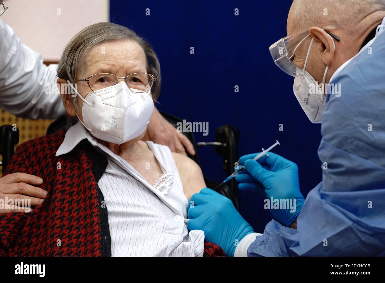 Berlin, Germany. 27th Dec, 2020. 100-year-old Ruth Heller (l) is vaccinated against the corona virus by vaccinator Fatmir Dalladaku (r) at the Agaplesion Bethanien Sophienhaus nursing home. Corona vaccinations with the Covid-19 vaccine from Biontech/Pfizer began in Germany on Sunday.Corona vaccinations with the Covid-19 vaccine from Biontech/Pfizer began in Germany on Sunday. Credit: Kay Nietfeld/dpa Pool/dpa/Alamy Live News Stock Photo