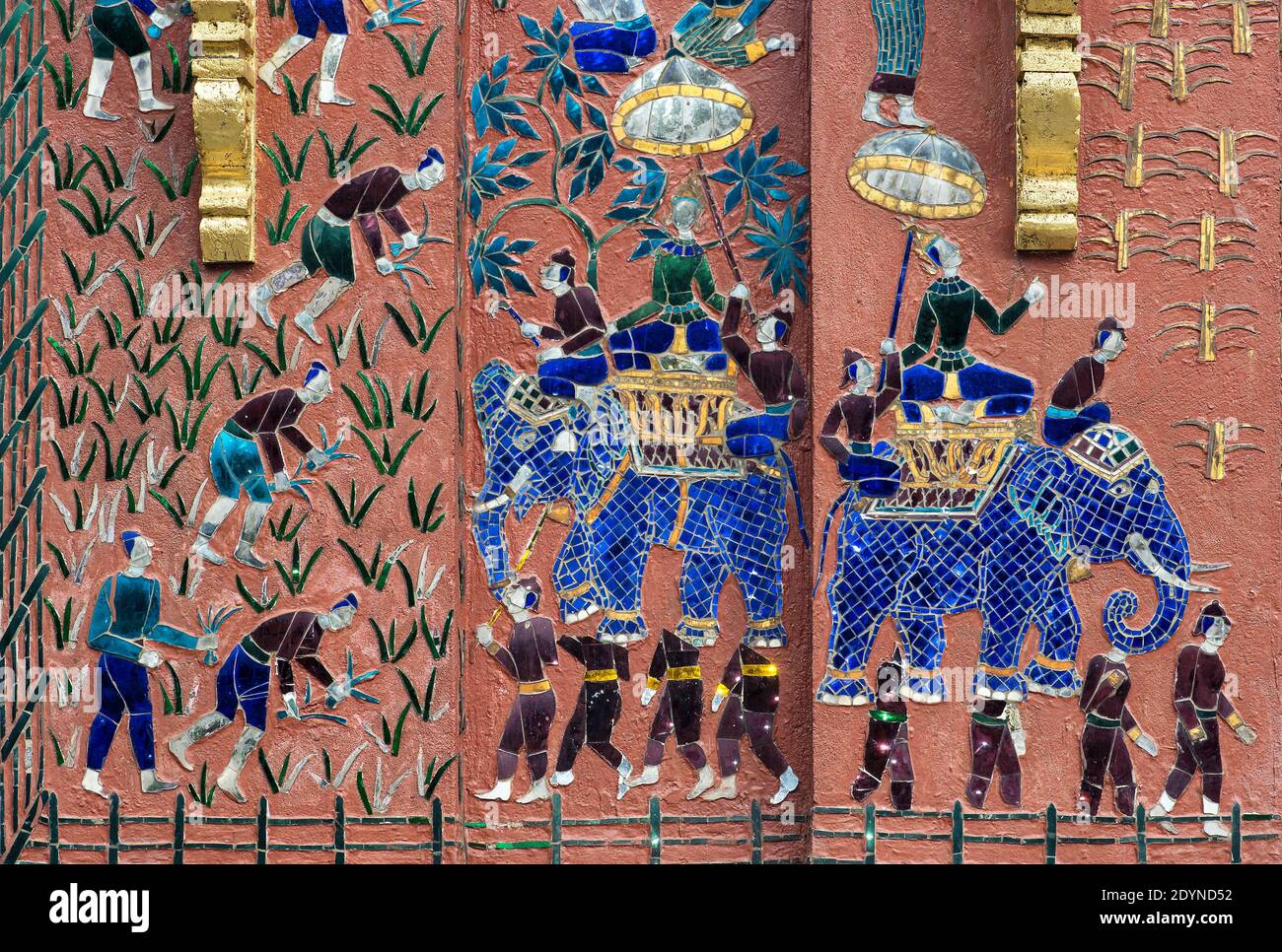Scenes from rural life as mosaic decorations on an outer wall of the Tripitaka library, Wat Xieng Thong temple, Luang Prabang, Laos Stock Photo