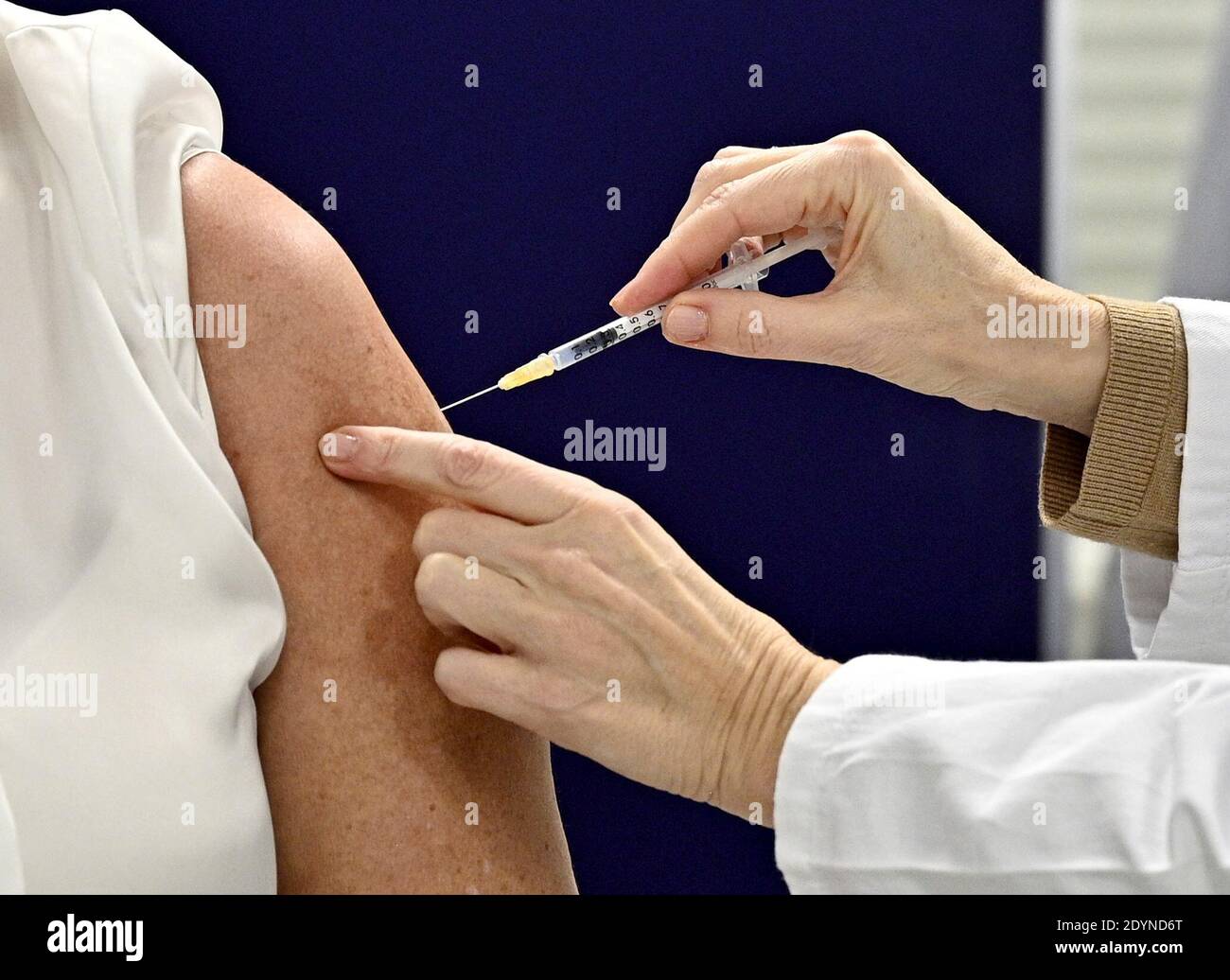 A woman receives the Pfizer/BioNTech COVID-19 vaccine at the MedUni Wien in Vienna, Austria December 27, 2020, the day when the country starts its vaccination programme. Hans Punz/Pool via Reuters Stock Photo