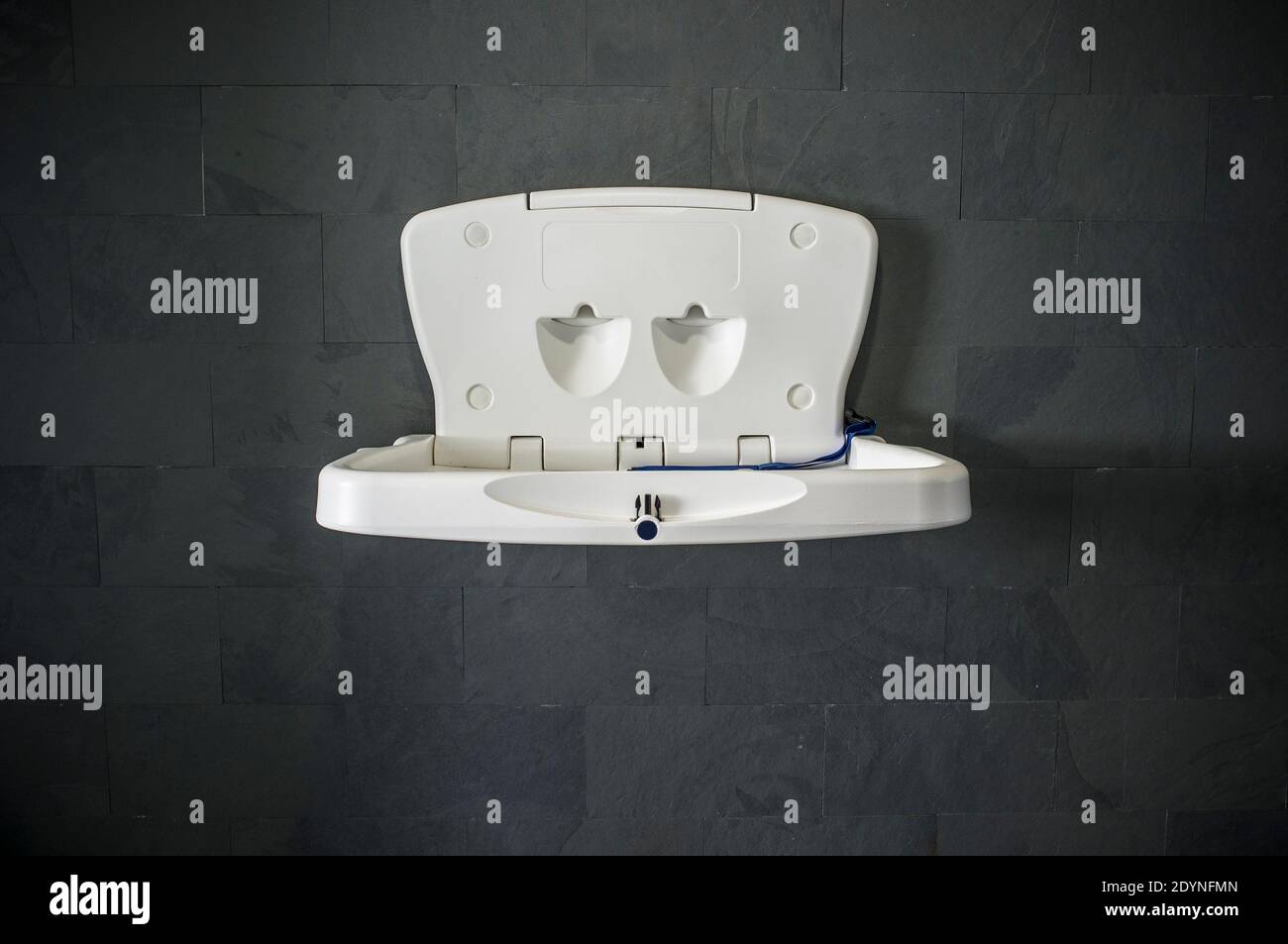 Baby changing station. Dark mineral wall background Stock Photo