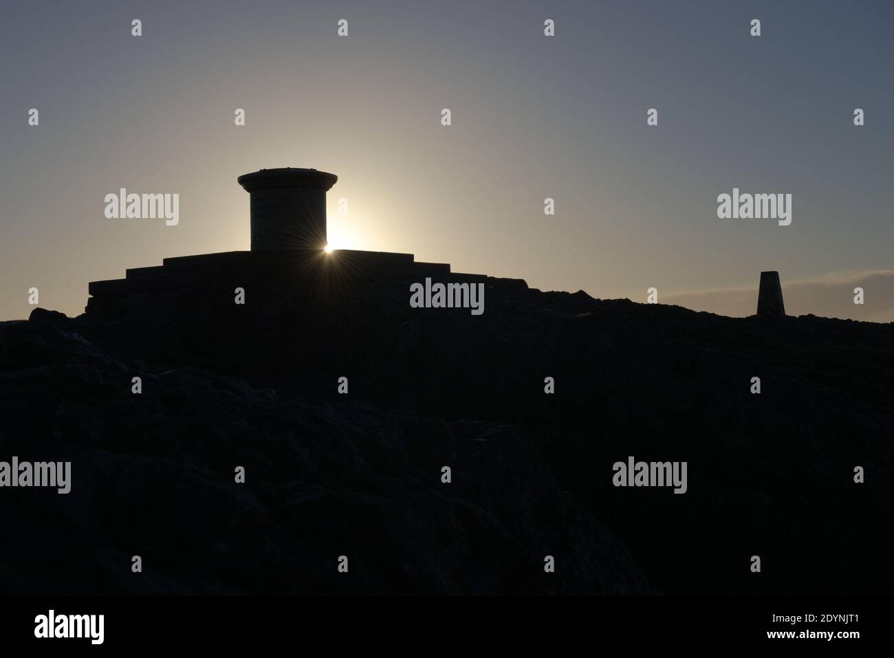 4 - Lens flare as the sun rises round the diamond jubilee toposcope at the top of the malvern hills. Area of natural beauty in worcestershire. Stock Photo