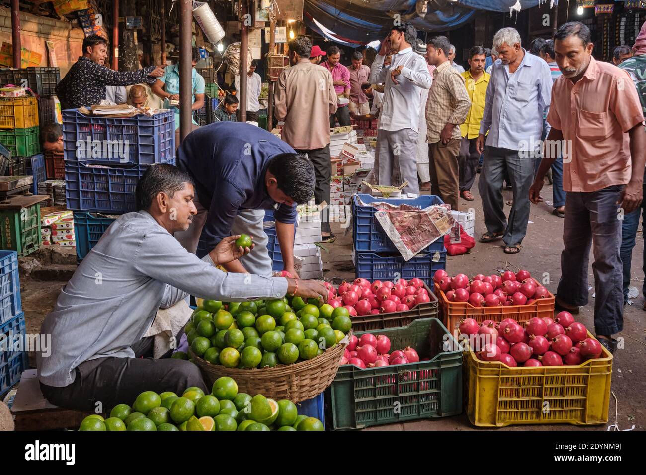 Market activity, shoppers & porters amidst fruit stalls in Crawford Market Mahatma Jyotiba Phule Mandai/Market), a major fruit market in Mumbai, India Stock Photo