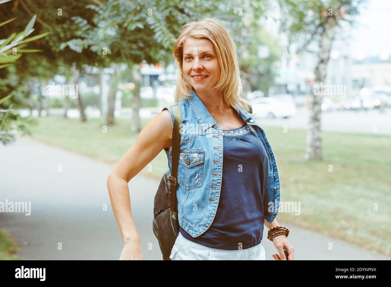 Beautiful young woman walking in a park in summer Stock Photo - Alamy