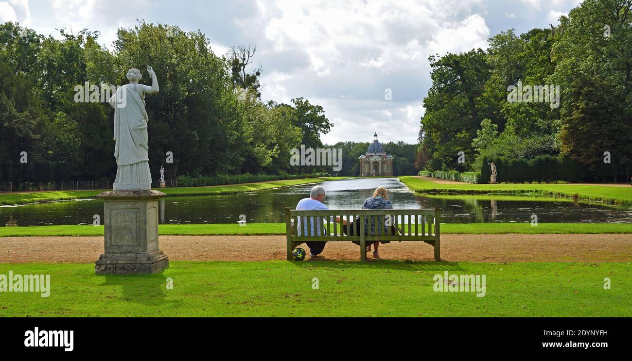 Couple sitting on bench overlooking the Thomas Archer pavillion and Long Canal at Wreat Park. Stock Photo
