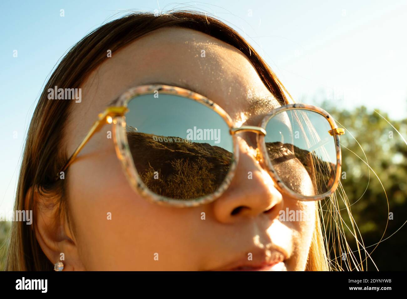 Closeup of girl looking at The Hollywood Sign, reflected in sunglasses. Los Angeles, California, US. Aug 2019 Stock Photo
