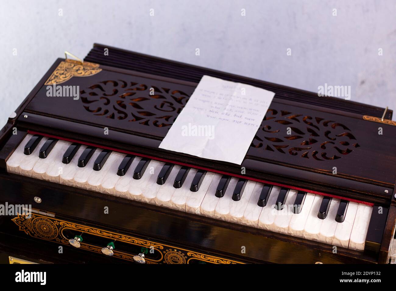 Harmonium or organ and musical notes in bengali language on white