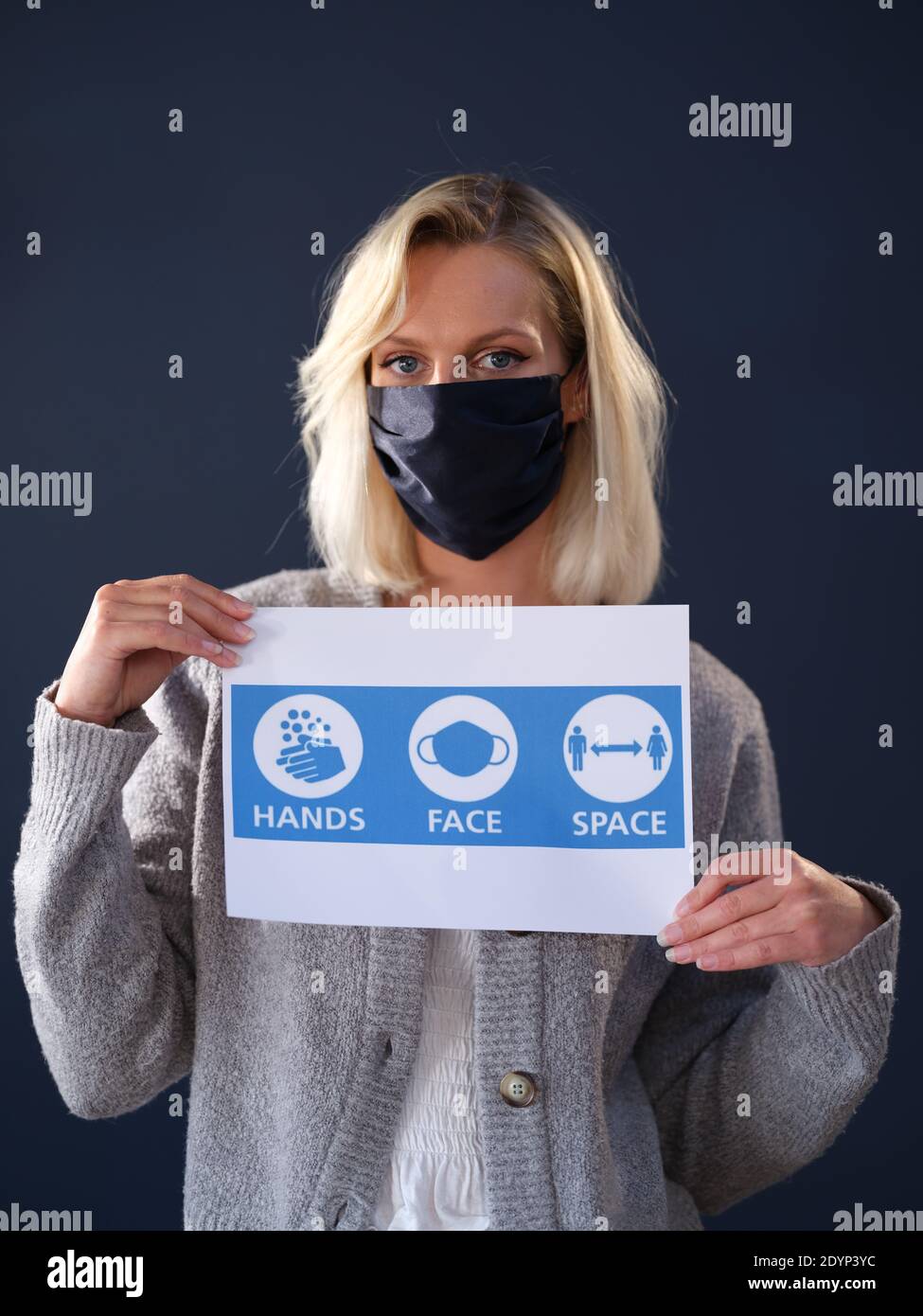 Portraits of Girl wearing Covid Coronavirus Mask holding NHS sign and