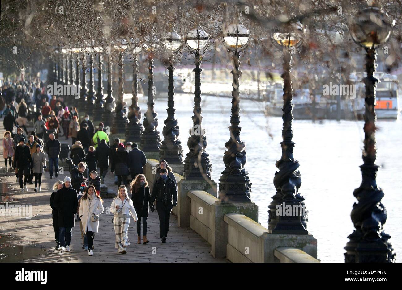 People walking past the rover Thames as they make their way along the South bank in London. Stock Photo