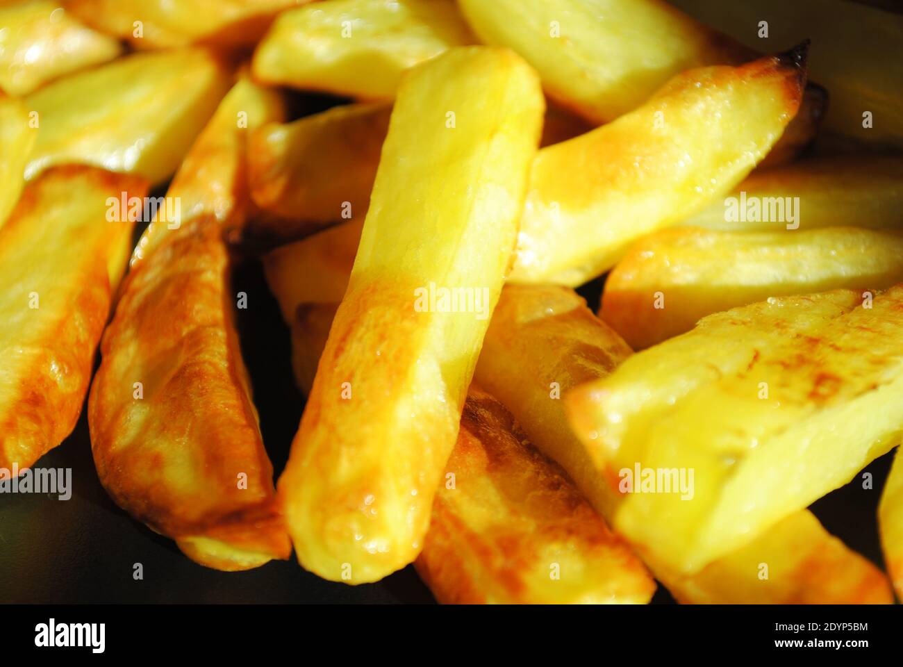 A close-up of a delicious portion of oven-baked potato chips. Stock Photo