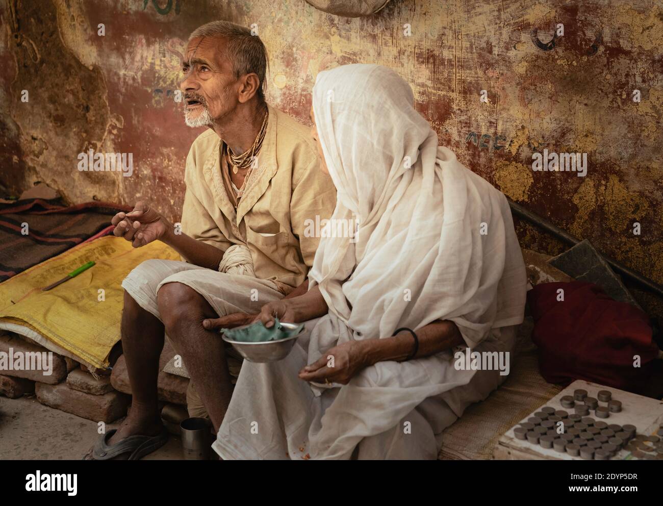 Widow seeking alms in market place along dingy street in Vrindavan