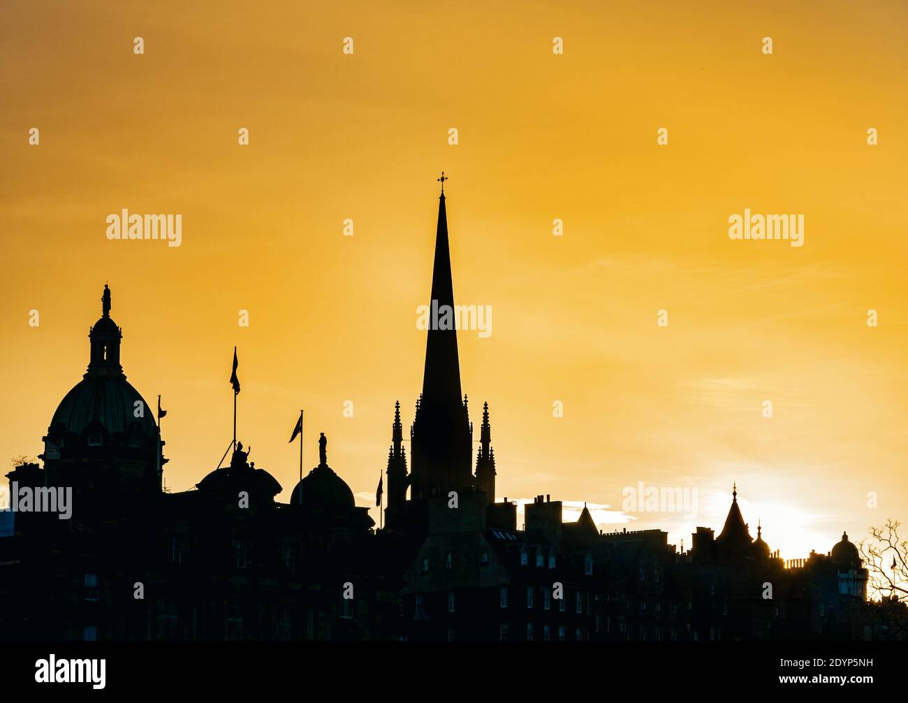 Silhouette of buildings in the city skyline at dusk with an orange sunset sky, Edinburgh, Scotland, UK Stock Photo