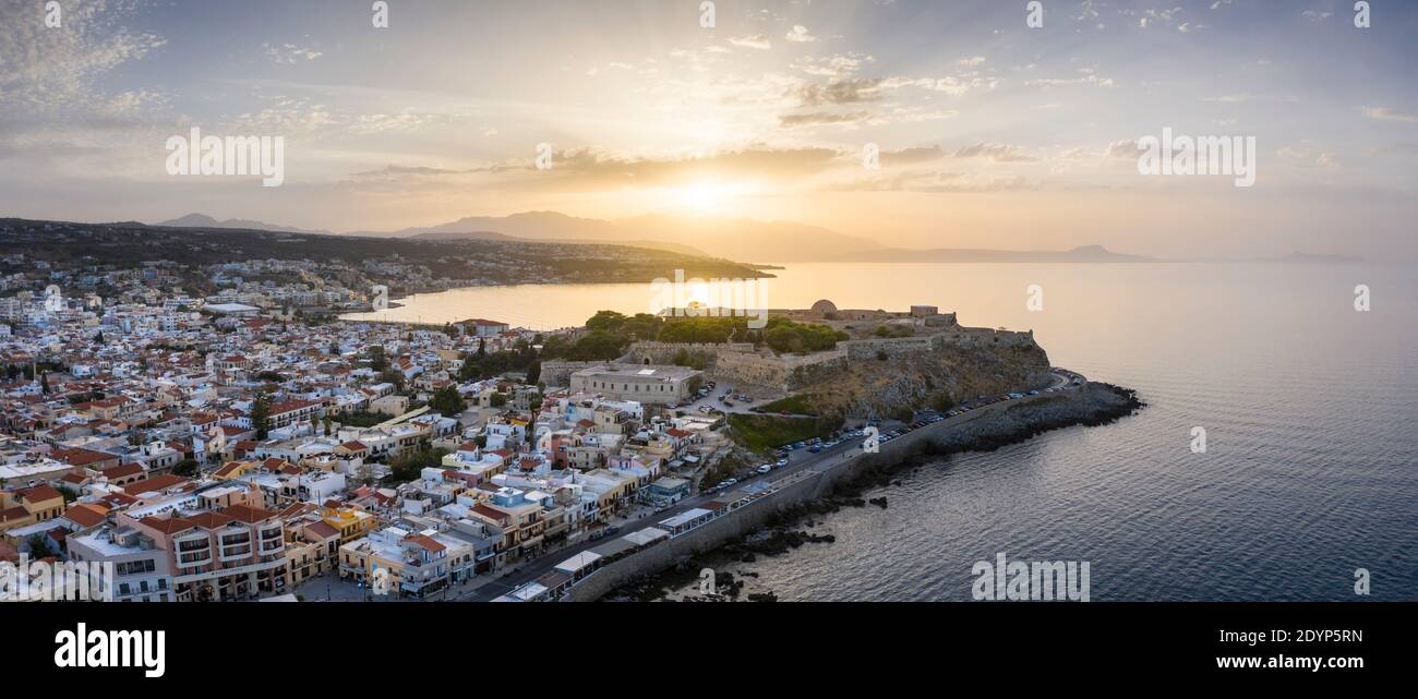 Aerial view of the city of Rethymno at sunset showing the old town, Fortezza Castle, and promenade, Crete, Greece Stock Photo