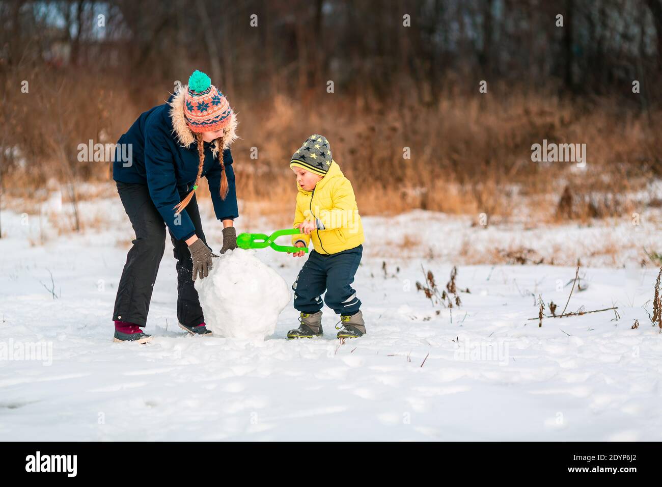Child Making Snowballs Child rolling snowball hi-res stock photography and images - Alamy