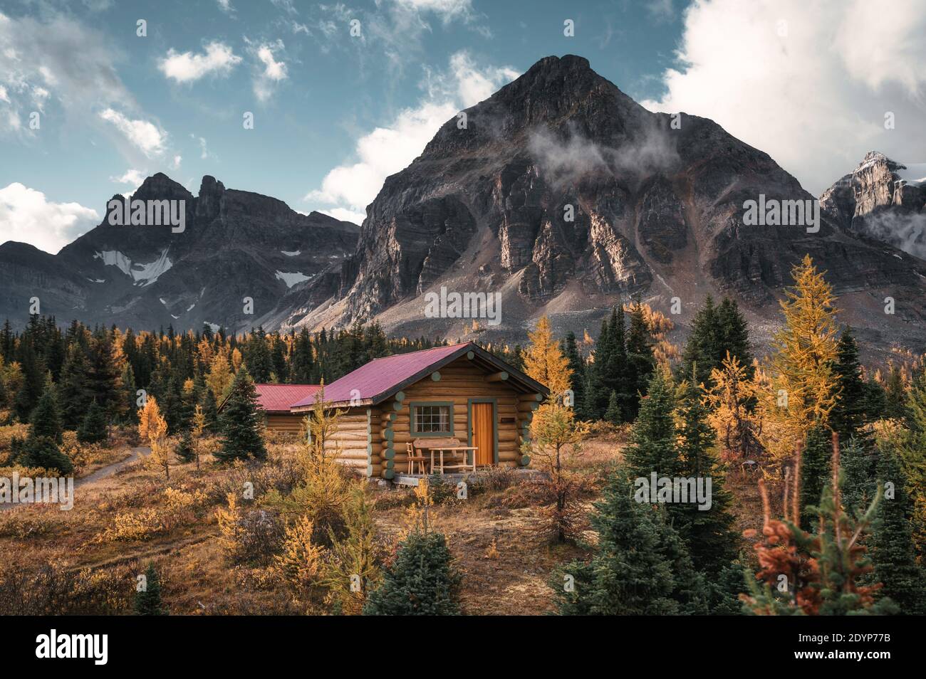Wooden huts with rocky mountains in autumn forest at Assiniboine ...