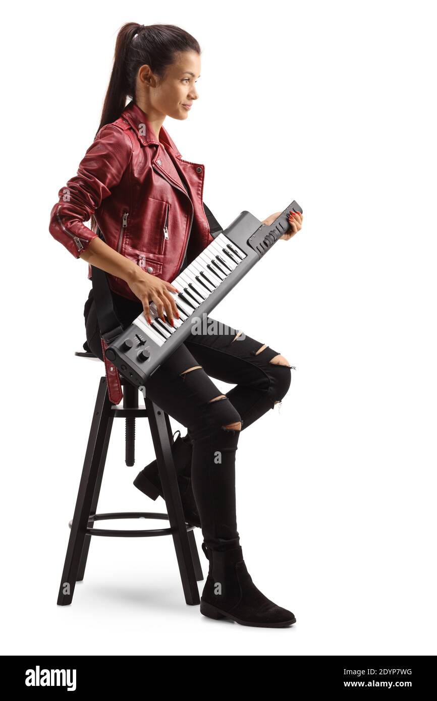 Young female musician playing a keytar and sitting on a tall bar chair isolated on white background Stock Photo