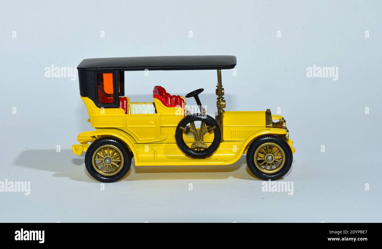 Toy diecast model of a Yellow 1907 Peugeot a Matchbox yesteryear product by Lesney with white background Stock Photo