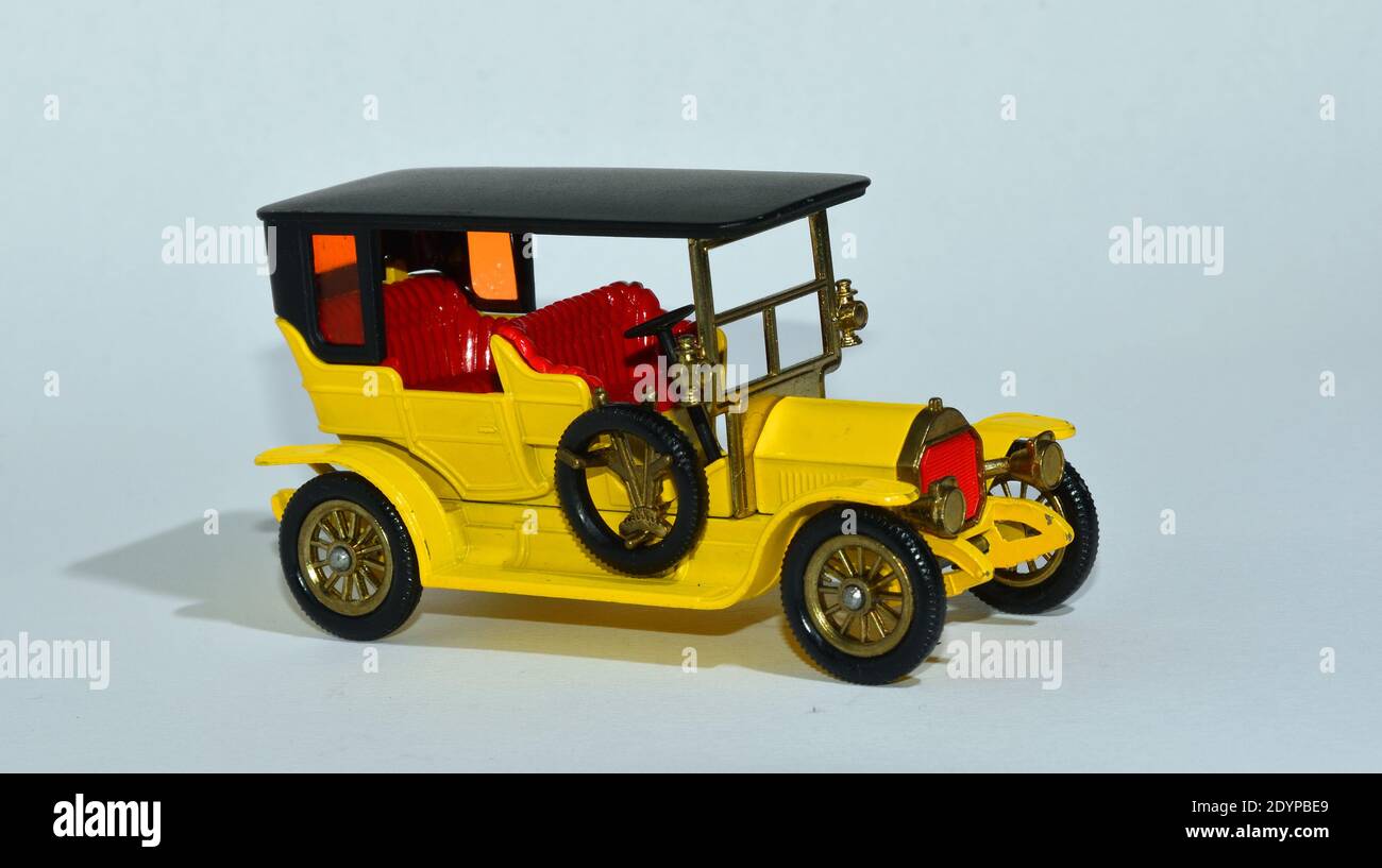 Toy diecast model of a Yellow 1907 Peugeot a Matchbox yesteryear product by Lesney with white background Stock Photo