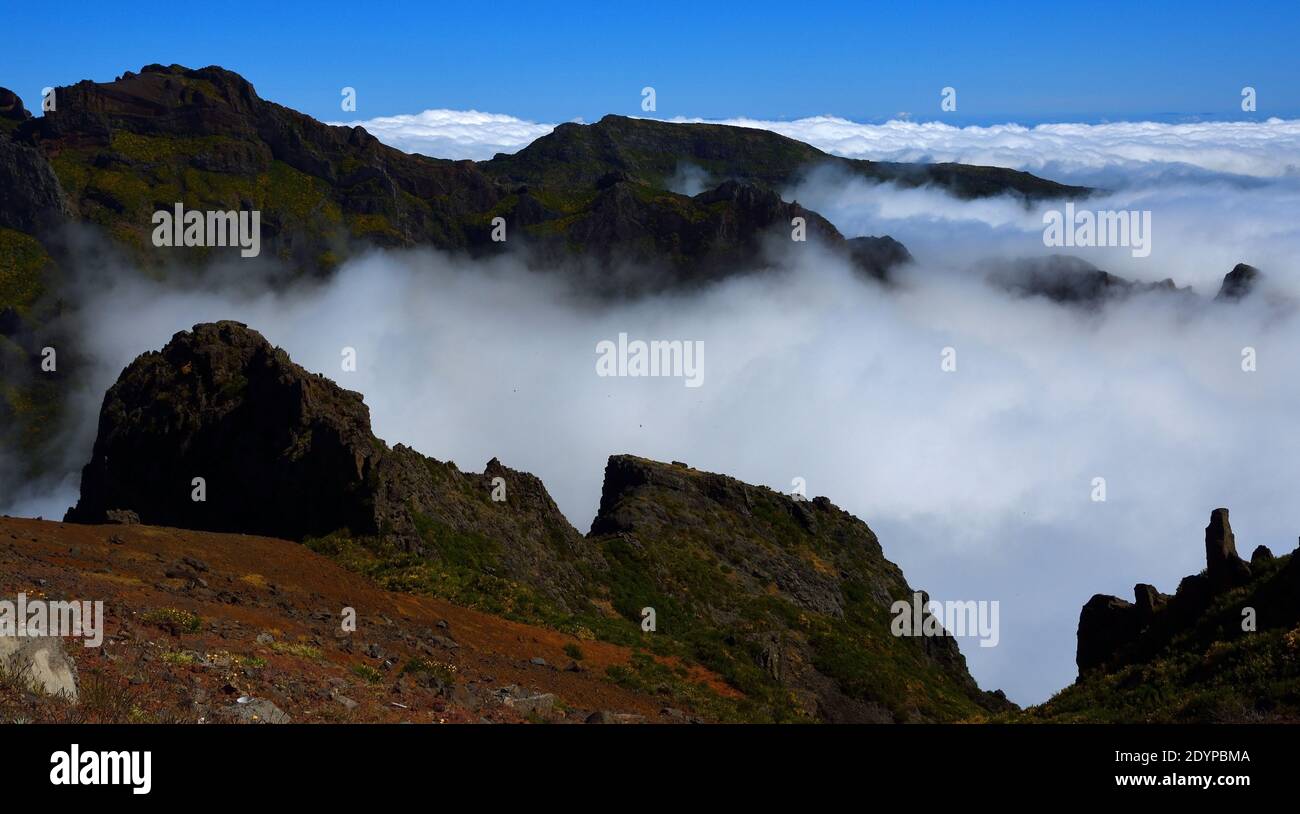 Pico do Areeiro Madeira peaks  among clouds with blue sky above. Stock Photo