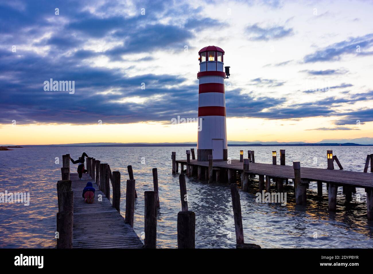 Podersdorf am See: lighthouse at Lake Neusiedl, girls take photos of an acrobatics exercise in Neusiedler See (Lake Neusiedl), Burgenland, Austria Stock Photo