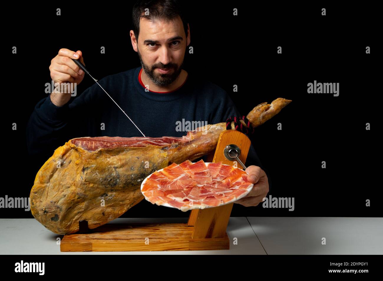 Bearded man with a ham knife ready to cut a piece of typical Spanish ...