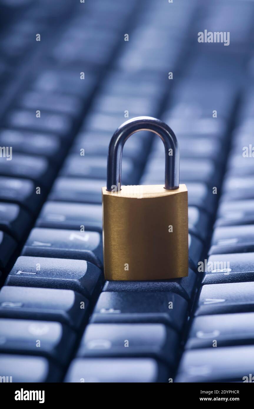 Locked metal padlock on blue computer keyboard. Data and password protection, internet and network security concept. Stock Photo