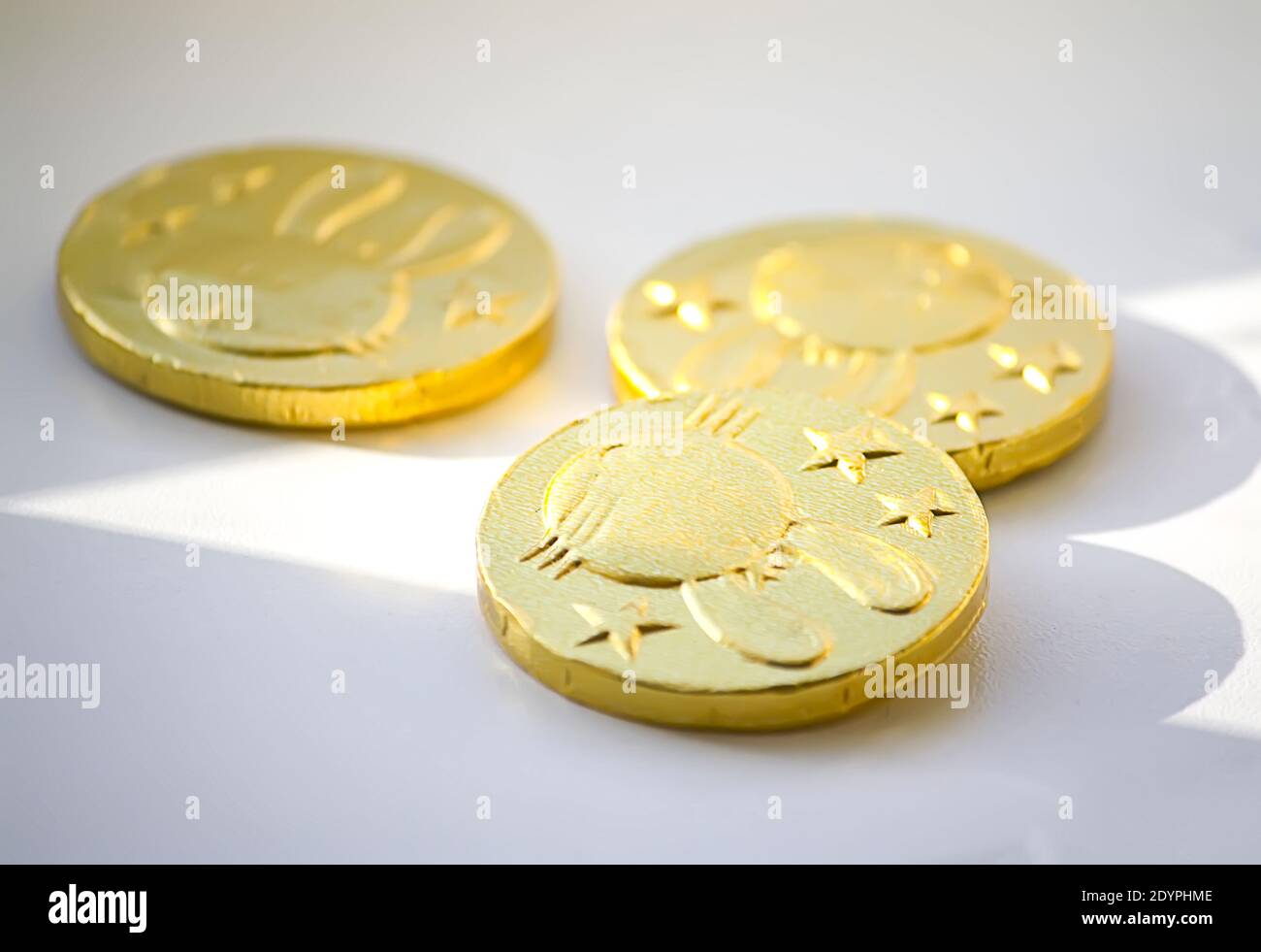 Gold foil wrapped chocolate coins on white background Stock Photo Alamy