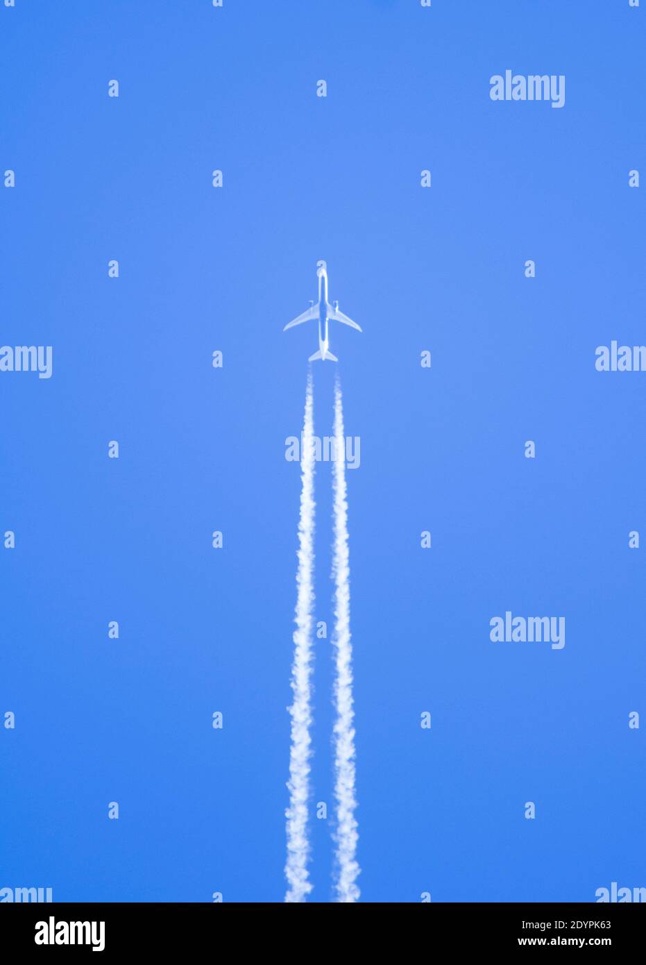 A airplane seen from below with the steam trails very marked. copy space Stock Photo