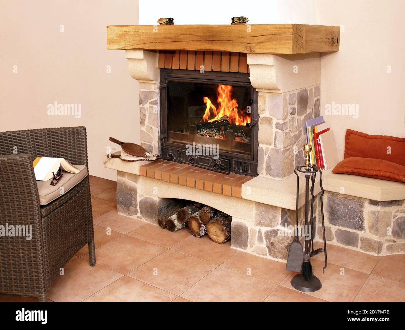 Quietude and warmth of fire in a stone and wood fireplace. Stock Photo