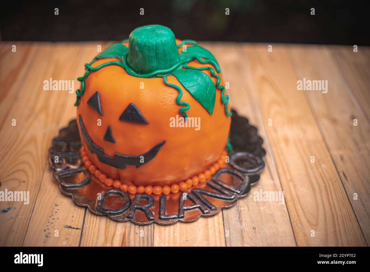 A delicious pumpkin shaped cake on a wooden table Stock Photo