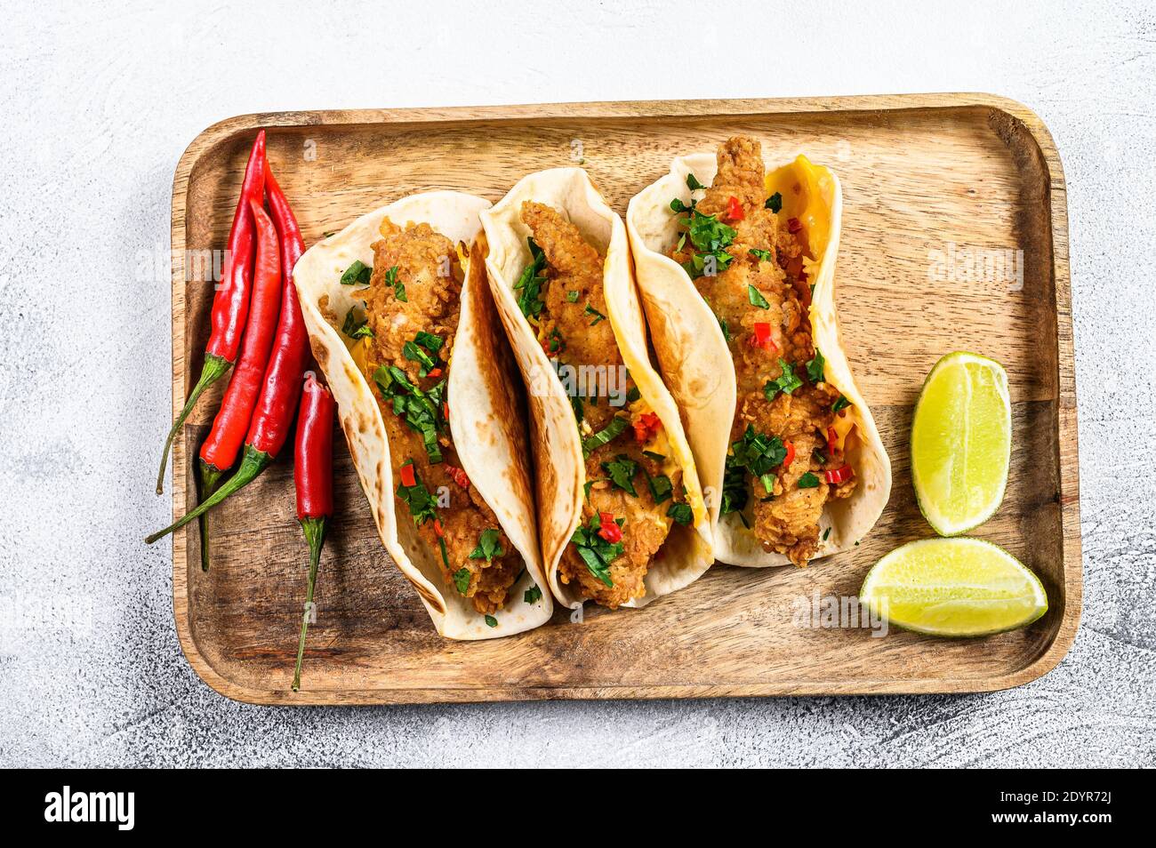 Traditional Mexican tacos with parsley, cheese and chili peppers. White background. Top view Stock Photo