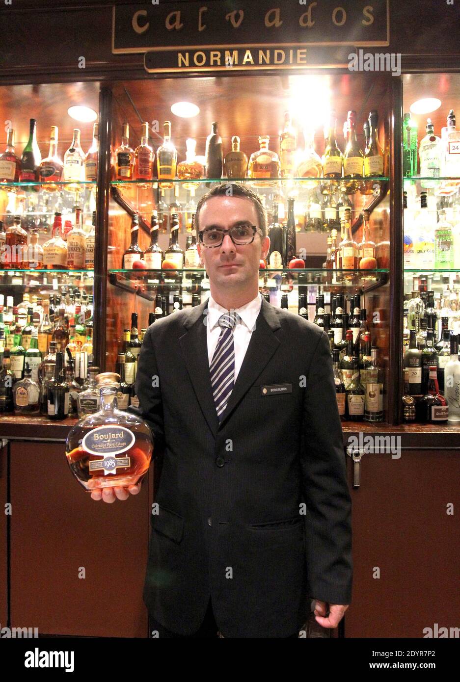 Boris Burtin, Restaurant and Bar manager with Jose Torrella Jr, Mixologist at the Barclay Bar at the Intercontinental in New York City, discusse the 30 types of the French apple brandy Calvados that the bar houses on July 5, 2013. Honored as the 'First Calvados Bar' in the US, the bar's menu offers a cocktail featuring calvados and apple juice from New York apples, 'flights' featuring four one-ounce tastings, and a 1939 vintage 'Apellation Calvados', priced at $198. A twice-distilled brandy from Normandy, Calvados blends over two dozen types of apples creating its distinct flavor and aroma. Ph Stock Photo