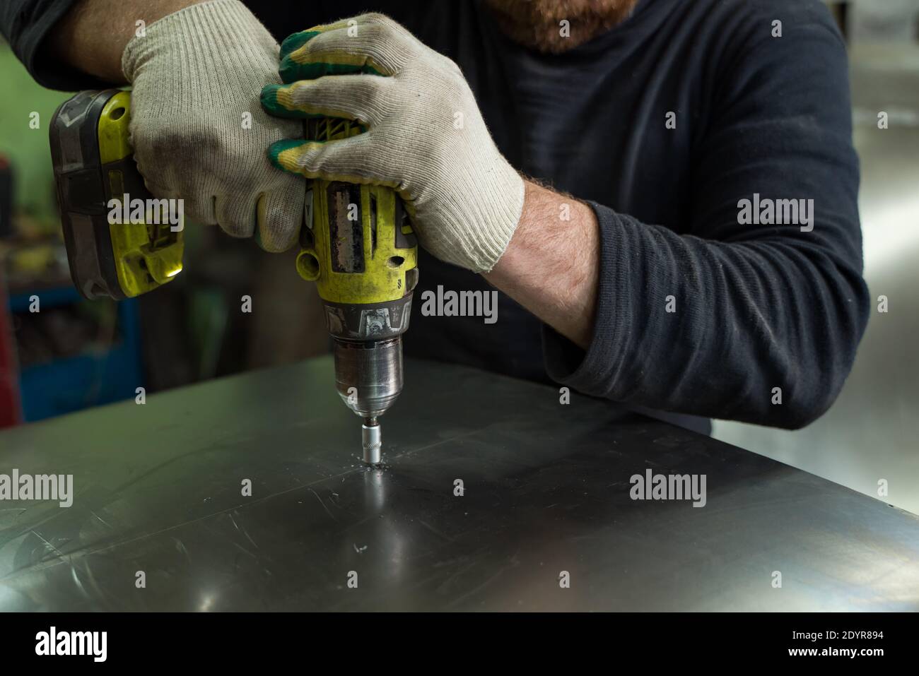 Man Works in Auto Workshop with Cordless Screwdriver Stock Photo