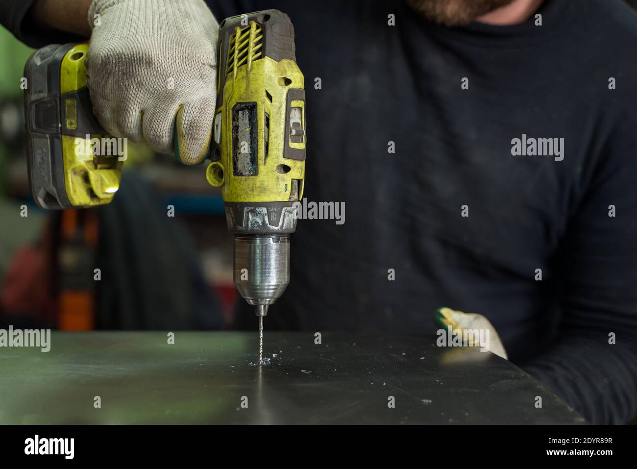 Man Works in Auto Workshop with Cordless Screwdriver Stock Photo
