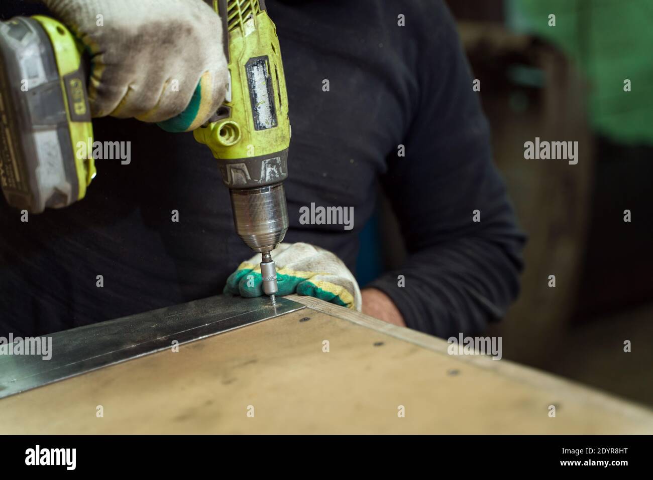Man Works in Auto Workshop with Cordless Screwdriver Stock Photo