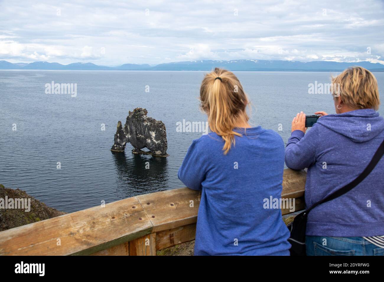 tourists looking at rocks t se at Hvitserkur in Iceland Stock Photo